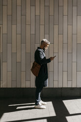 Man texting on street in Stockholm, Sweden - FOLF04858