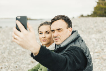 Young couple taking selfie at beach - FOLF04866