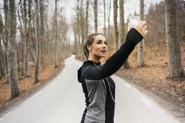 Junge Frau nimmt Selfie auf Landstraße - FOLF04891