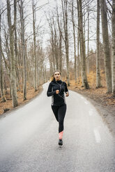 Young woman running on rural road - FOLF04893