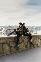 Couple sitting on stone wall in Stockholm, Sweden - FOLF04899