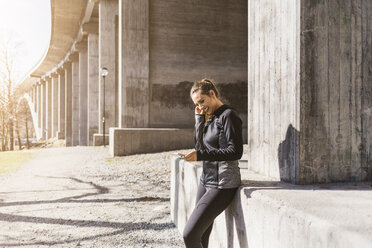 Young woman with smart phone on street in Stockholm, Sweden - FOLF04909