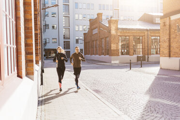 Man and woman running along street in Stockholm, Sweden - FOLF04913