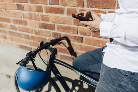 Mann auf dem Fahrrad schreibt eine SMS, lizenzfreies Stockfoto