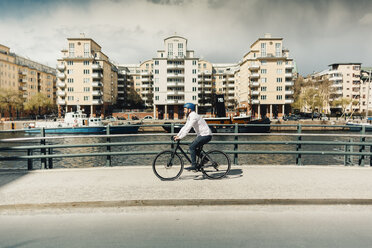 Mann fährt mit dem Fahrrad auf der Straße in Stockholm, Schweden - FOLF04922