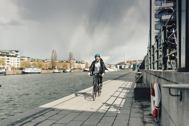 Mann fährt mit dem Fahrrad auf der Straße in Stockholm, Schweden - FOLF04923