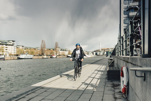 Mann fährt mit dem Fahrrad auf der Straße in Stockholm, Schweden - FOLF04923