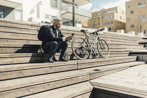 Mann auf einer Treppe mit Fahrrad in Stockholm, Schweden - FOLF04925