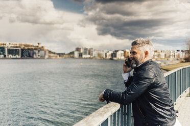 Man on smart phone at waterfront in Stockholm, Sweden - FOLF04930