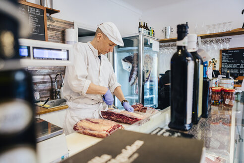 Fleischer beim Schneiden von Fleisch - FOLF04931