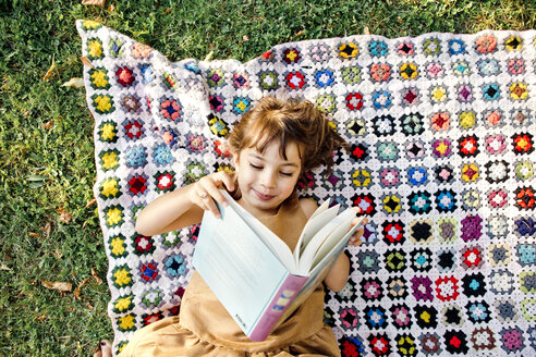 Girl reading on picnic blanket - FOLF05091