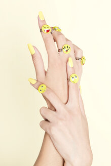 Close-up of woman's hands with emojis on rings - SRYF00782