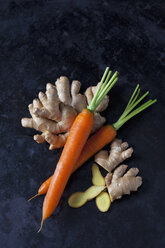 Frischer Ingwer und Karotten auf dunklem Metall - CSF29022