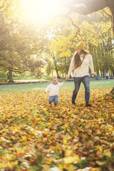 Mutter und Sohn spielen im Herbstlaub - FOLF05229