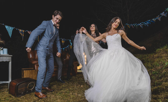 Glückliche Braut tanzt und hat Spaß mit ihren Freunden auf einem Nachtfeld Party - DAPF00940