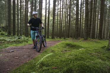 Mature man with bicycle in forest - FOLF05524