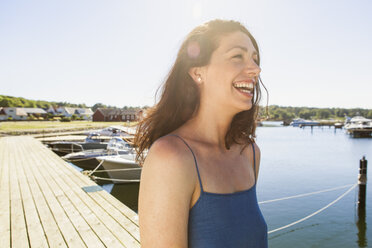 Fröhliche Frau beim Spaziergang am Pier - FOLF05601