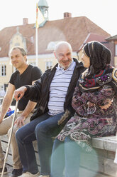 Portrait of people sitting on brick wall - FOLF05630