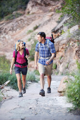 Happy couple walking on road against mountain - CAVF31169