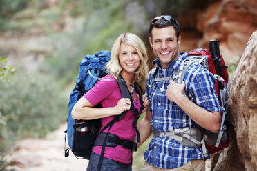 Portrait of couple with backpacks during hiking - CAVF31174