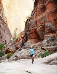 Woman jogging on field against mountain - CAVF31177