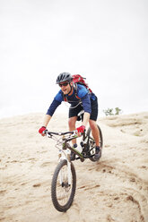 Mann fährt Fahrrad auf einem Berg gegen den klaren Himmel - CAVF31205