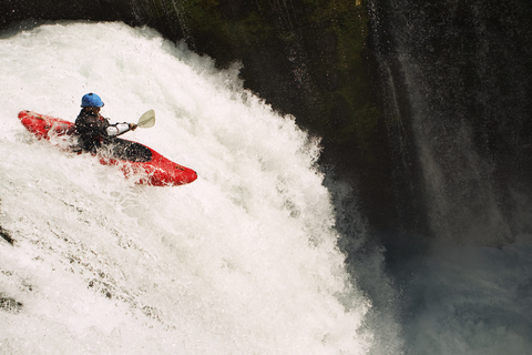 Man kayaking on waterfall on river stock photo