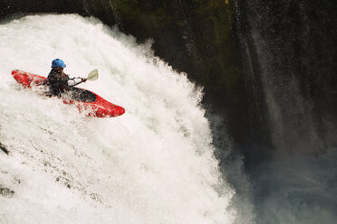 Mann fährt Kajak auf Wasserfall auf Fluss - CAVF31250