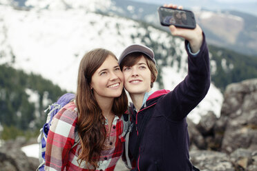 Female friends taking selfie while standing on mountain - CAVF31320