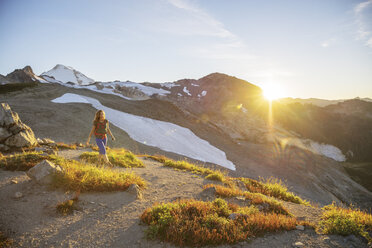 Female hiker hiking on mountain against sky - CAVF31346