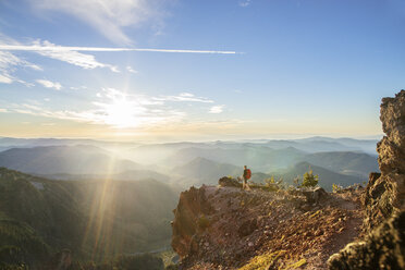 Male hiker standing on mountain against sky during sunny day - CAVF31355