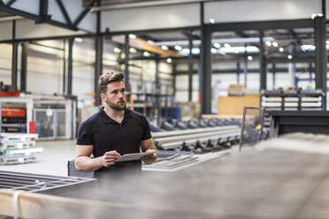 Man using tablet on factory shop floor - DIGF03588