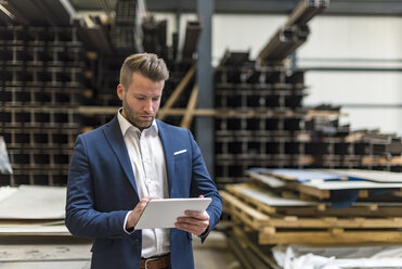 Geschäftsmann mit Tablet in einer Fabrikhalle stehend - DIGF03594