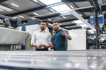 Two men with tablet discussing on factory shop floor - DIGF03607