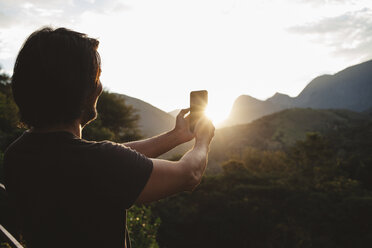 Mann spricht Selfie, während er gegen Berge steht - CAVF31380