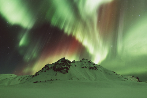 Schneebedeckter Berg gegen Polarlicht, lizenzfreies Stockfoto