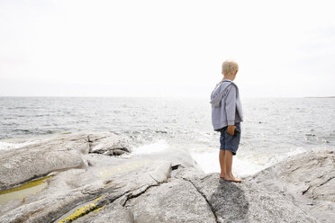 Boy standing on rocky seashore in the Stockholm archipelago - FOLF05735