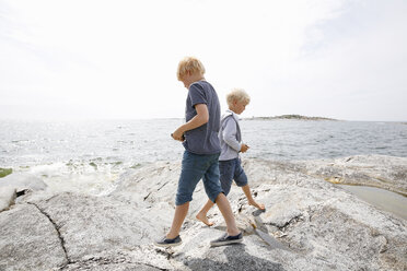 Zwei Jungen gehen am felsigen Meeresufer in den Stockholmer Schären spazieren - FOLF05737