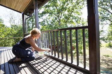 Ältere Frau malt Verandageländer - FOLF05744