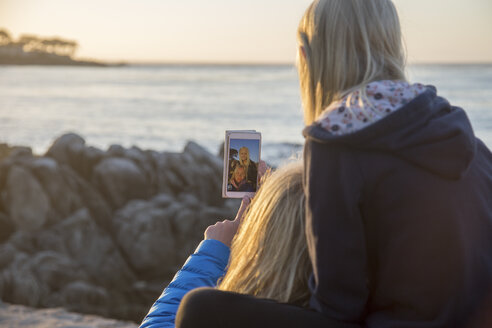 Mädchen fotografiert sich und ihre Mutter in Pacific Grove - FOLF05795