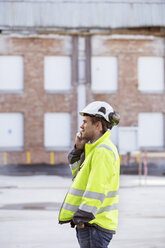 Mann benutzt Smartphone auf einer Baustelle - FOLF05809