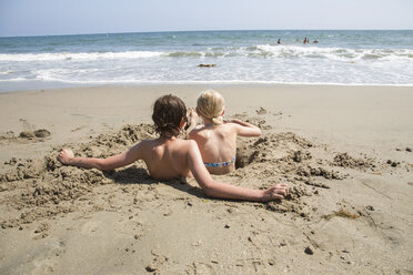 Junge und Mädchen in einem Loch im Sand am Strand von Santa Barbara - FOLF05812