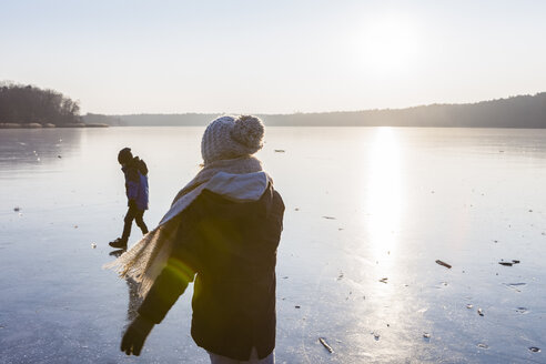 Deutschland, Brandenburg, Straussee, zwei Kinder spazieren auf zugefrorenem See - OJF00252