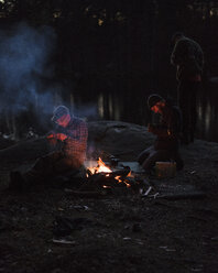 Männer am Lagerfeuer in der Abenddämmerung - FOLF05918