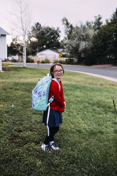 Porträt eines Mädchens mit Rucksack auf einer Wiese - CAVF31550