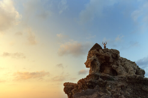 Niedriger Blickwinkel von Wanderer stehend auf Felsformation gegen Himmel während Sonnenuntergang - CAVF31616