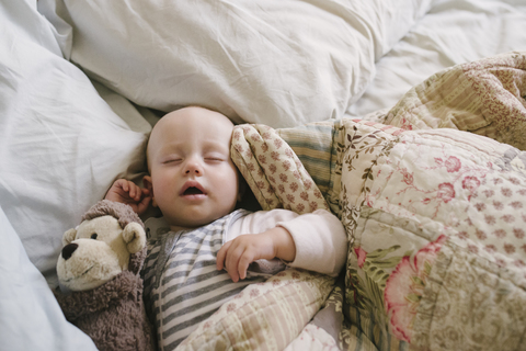 Draufsicht auf ein kleines Mädchen, das zu Hause im Bett schläft, lizenzfreies Stockfoto