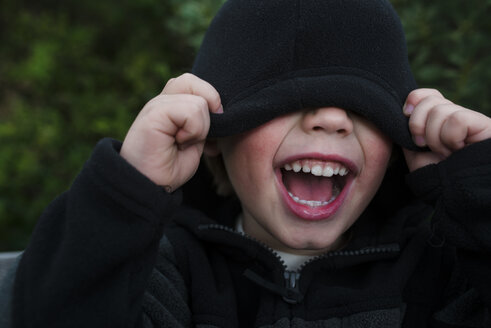 Boy screaming while covering eyes with hooded shirt - CAVF31659