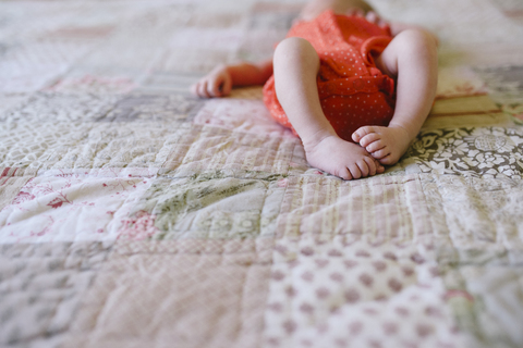 Hohe Winkel Ansicht von Baby-Mädchen entspannt auf Bett zu Hause, lizenzfreies Stockfoto