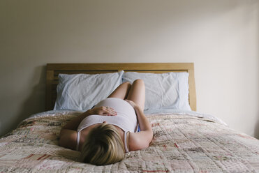 Schwangere Frau entspannt sich auf dem Bett zu Hause - CAVF31669